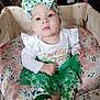 Laylani joined the competition — help win amazing prizes! baby, infant, child, headband, bow, face, eyes, crib, boppy_pillow, blanket, onesie, skirt, green_clothing, st_patricks, patterned_pillow, cute, sitting, foot, hand, indoors