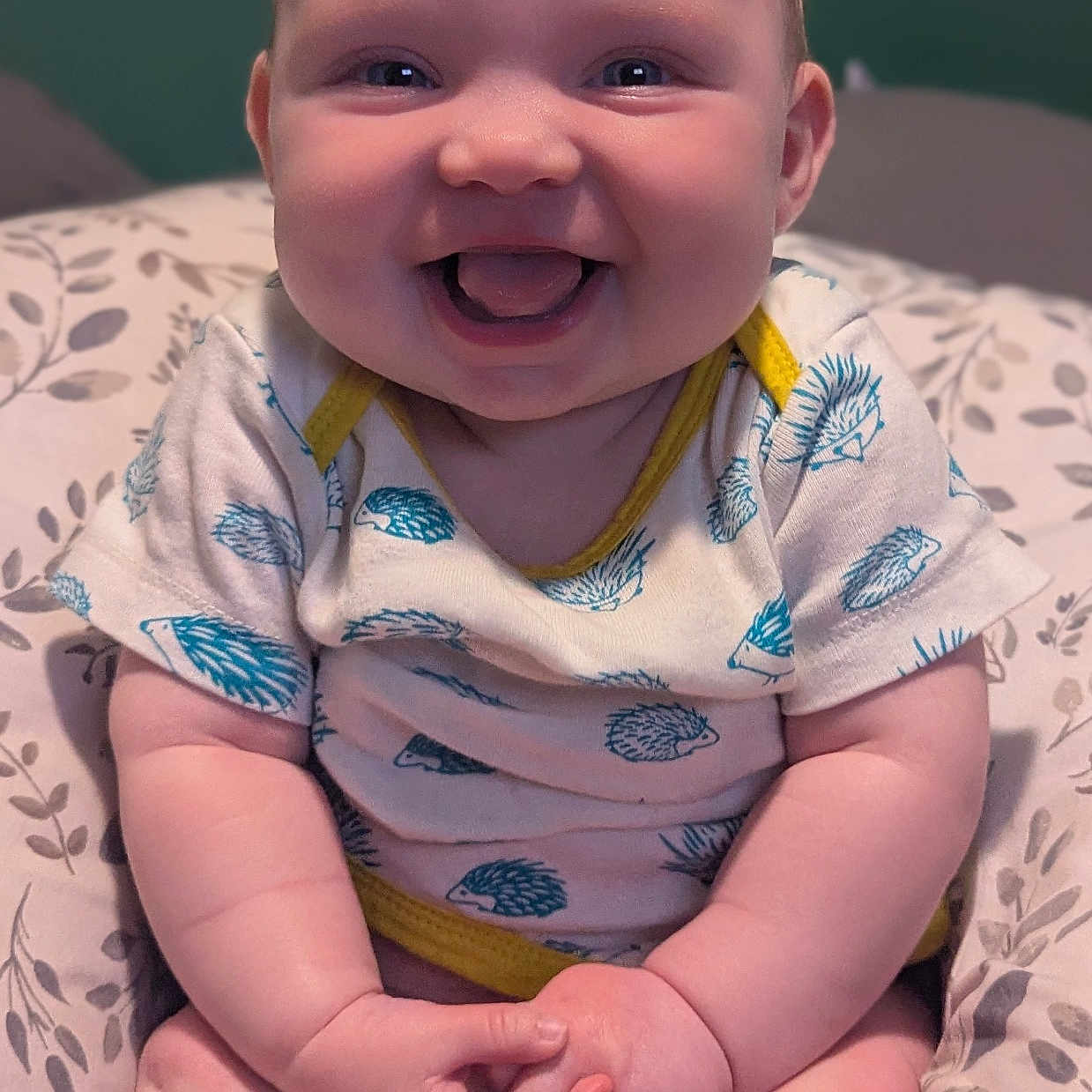 Tessa is registered to the contest to win money with this photo: baby, babylaughing, bodypart, clothing, couch, dress, face, furniture, happy, head, homedecor, laughing, mouth, person, photography, portrait, sitting, smile, t_shirt, teeth