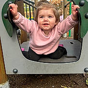 Shelby joined the competition — help win amazing prizes! toddler, child, playground, smiling, happy, outdoor, portrait, play_equipment, pink_sweater, black_pants, blonde_hair, face, eyes, hands, sitting, autumn, trees, wood, adventure, daylight