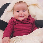 Clémentine participe au concours pour gagner de l'argent avec cette photo : baby, infant, smile, face, blanket, clothing, cozy, cute, child, portrait, warm, soft, happy, indoors, newborn, pacifier, fingers, head, skin, expression