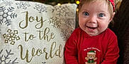 Emberlynn is registered to the contest to win money with this photo: baby, bright_eyes, child, christmas_tree, couch, cute, decorations, face, festive, happy, headband, holiday, indoors, joy_to_the_world, pillow, red_clothing, sitting, smiling, teddy_bear, text