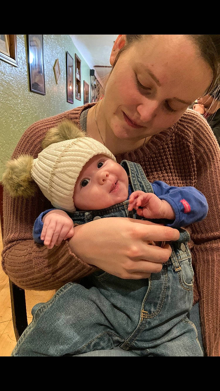 Amilia is registered to the contest to win money with this photo: arm, baby, baby_toddler_clothing, cheek, child, comfort, face, fun, gesture, grass, happy, headwear, jeans, lap, mouth, organ, person, picture_frame, sitting, skin