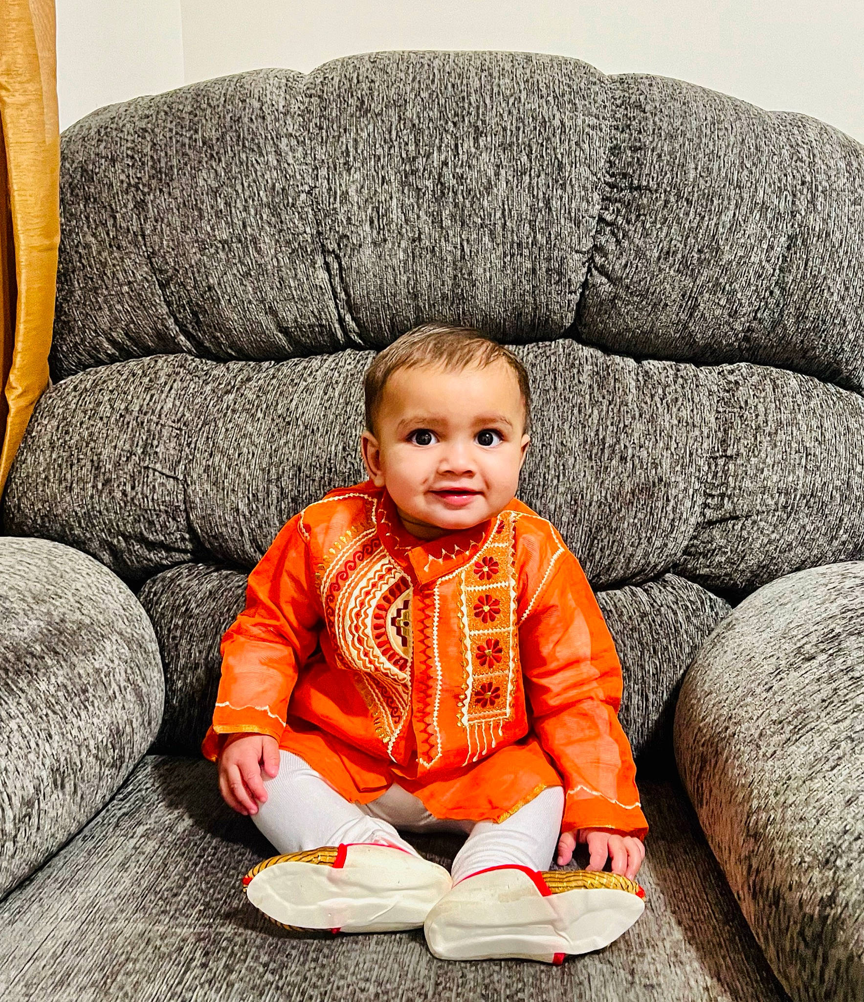 Aryan joined the competition — help win amazing prizes! baby, baby_toddler_clothing, comfort, couch, facial_expression, floor, flooring, hairstyle, happy, jacket, joy, leg, person, sitting, sleeve, smile, standing, textile, toddler, walking_shoe