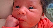 Ambria is registered to the contest to win money with this photo: baby, close_up, curious, cute, expression, face, hand, indoors, infant, newborn, orange_clothing, person, portrait, resting, skin, sleepy, small_hands, soft_light, toddler, young_child