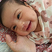 Doha Mehrish joined the competition — help win amazing prizes! baby, smile, face, hand, blanket, floral_pattern, infant, closeup, cute, skin, person, child, expression, joy, newborn, resting, warm, soft, comfort, lying_down