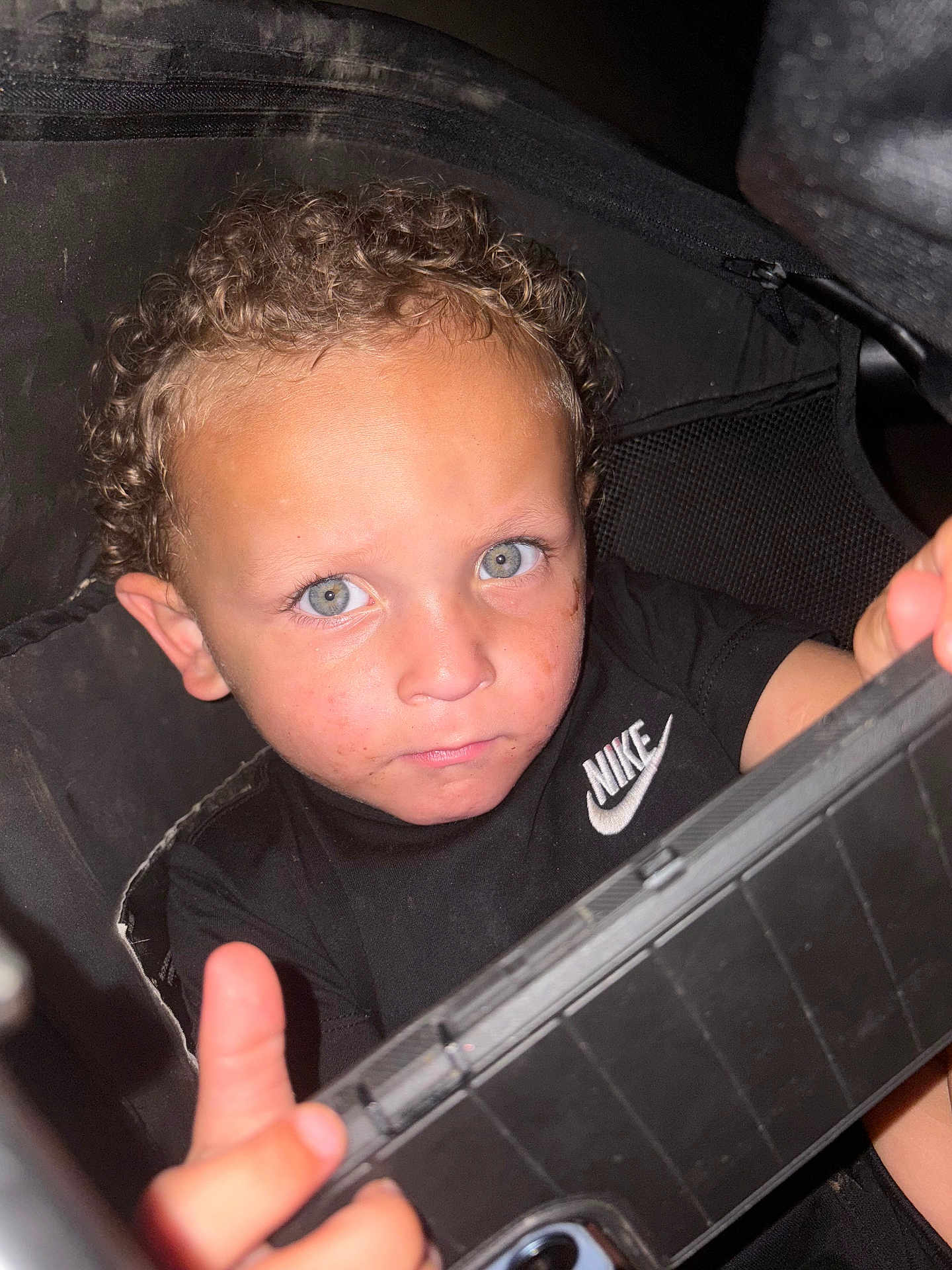 Zayden joined the competition — help win amazing prizes! child, boy, curly_hair, blue_eyes, black_shirt, nike_logo, indoor, portrait, face, looking_at_camera, holding_object, young, casual_clothing, closeup, expression, person, childhood, cute, curious, grip