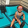Zayden joined the competition — help win amazing prizes! child, toddler, sunglasses, smile, outdoor, summer, tank_top, shorts, shoes, cushion, patio_furniture, wicker, happy, sunlight, curly_hair, relaxing, playful, bright_colors, casual, fun