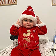 Leysson participe au concours pour gagner de l'argent avec cette photo : baby, child, infant, red_clothing, santa_hat, mickey_mouse, holiday_outfit, polka_dot, changing_pad, indoor, portrait, cute, smiling, festive, hat, hands_up, bright_eyes, wall_art, baby_fashion, playful