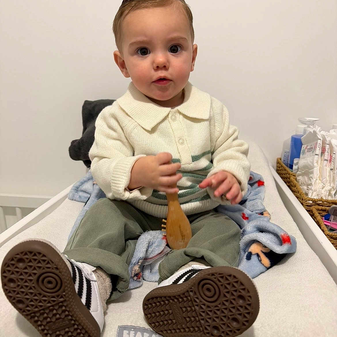 Leysson participe au concours pour gagner de l'argent avec cette photo : baby, baby_products, basket, blanket, changing_table, child, clothing, curious, expression, face, footwear, hair, indoor, person, room, sitting, sneakers, toddler, toy, wooden_brush