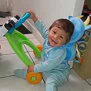 Ayden a rejoint le concours — aidez-le/la à gagner de superbes lots ! toddler, child, toy_walker, floor, smiling, blue_outfit, backpack, indoor, playful, happy, baby, colorful_toy, tile_floor, person, cute, young_child, light_blue, sitting, playtime, home