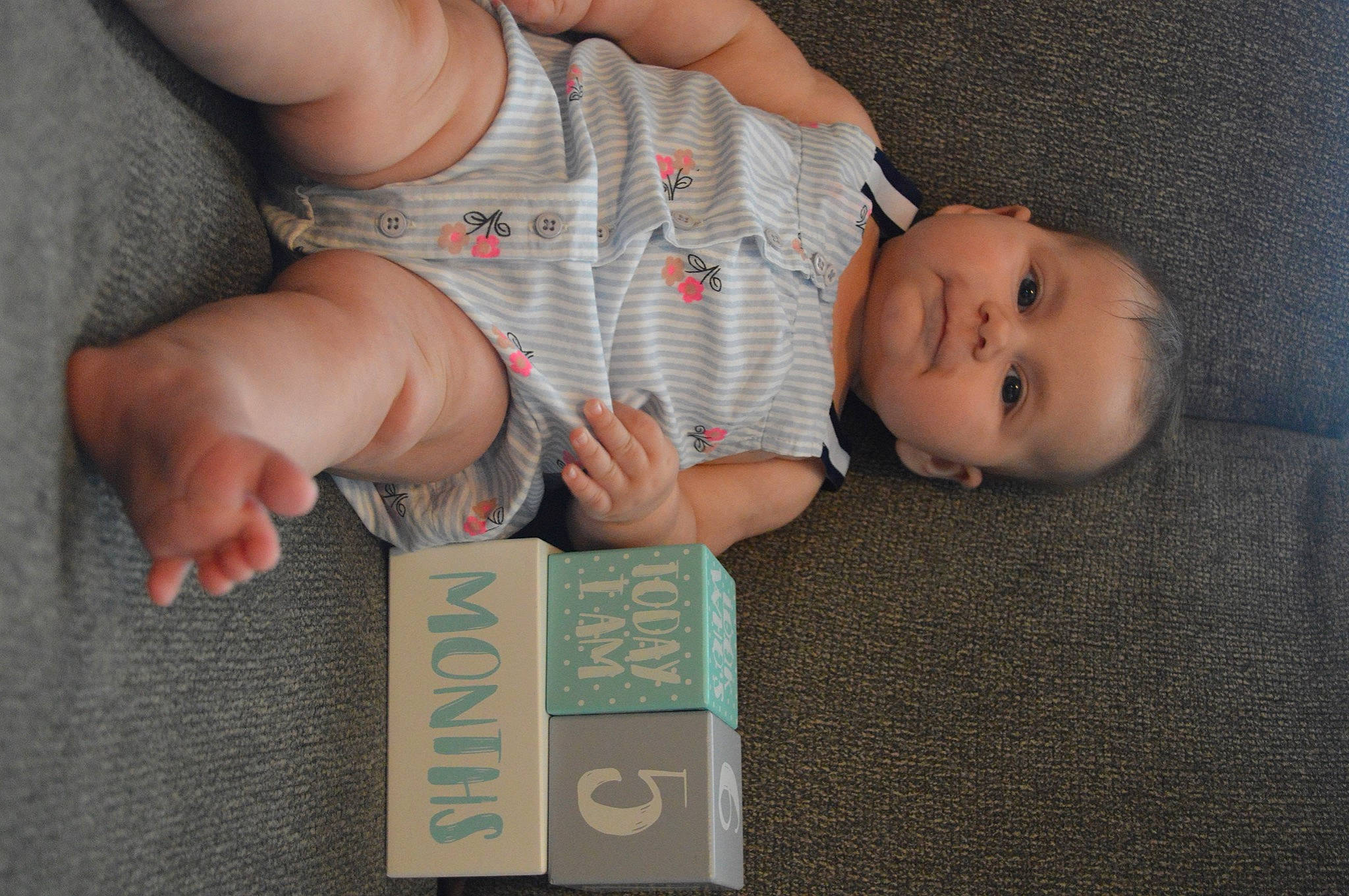 Evelynn is registered to the contest to win money with this photo: baby, baby_toddler_clothing, child, comfort, elbow, finger, flooring, foot, fun, gesture, hand, happy, head, nail, person, product, thigh, thumb, toddler, wood