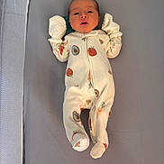 Willow is registered to the contest to win money with this photo: baby, infant, onesie, mittens, sleeping_bed, gray_background, cute, fruit_pattern, vegetable_pattern, newborn, soft_fabric, lying_down, cozy, small_hands, footed_pajamas, child, portrait, indoors, peaceful, adorable