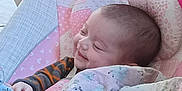 Destiny is registered to the contest to win money with this photo: baby, blanket, blue, child, clothing, cozy, cushion, cute, face, happy, indoor, infant, pink, portrait, quilt, resting, sleepy, smiling, wrapped, young