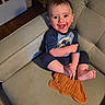 Jordan joined the competition — help win amazing prizes! baby, bookshelf, carpet, child, clothing, couch, cozy, door, face, foot, furniture, hand, happy, indoor, mickey_mouse, orange_cloth, person, sitting, smiling, wood_floor
