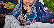 Jordy is registered to the contest to win money with this photo: toddler, child, smiling, hoodie, blue, blanket, outdoor, grass, tree, nature, happy, sitting, playful, cute, person, clothing, baby, toy, fabric, daylight