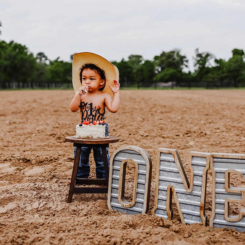 Cass joined the competition — help win amazing prizes! birthdaycake, boy, child, clothing, face, grass, happy, hat, head, male, outdoors, people, person, photography, plant, portrait, sitting, smile, summer, sunhat