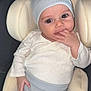 baby, infant, child, car_seat, beanie, hat, clothing, hand, fingers, face, eyes, cute, comfort, seat, ribbed_pants, sitting, indoor, portrait, young_child, casual
