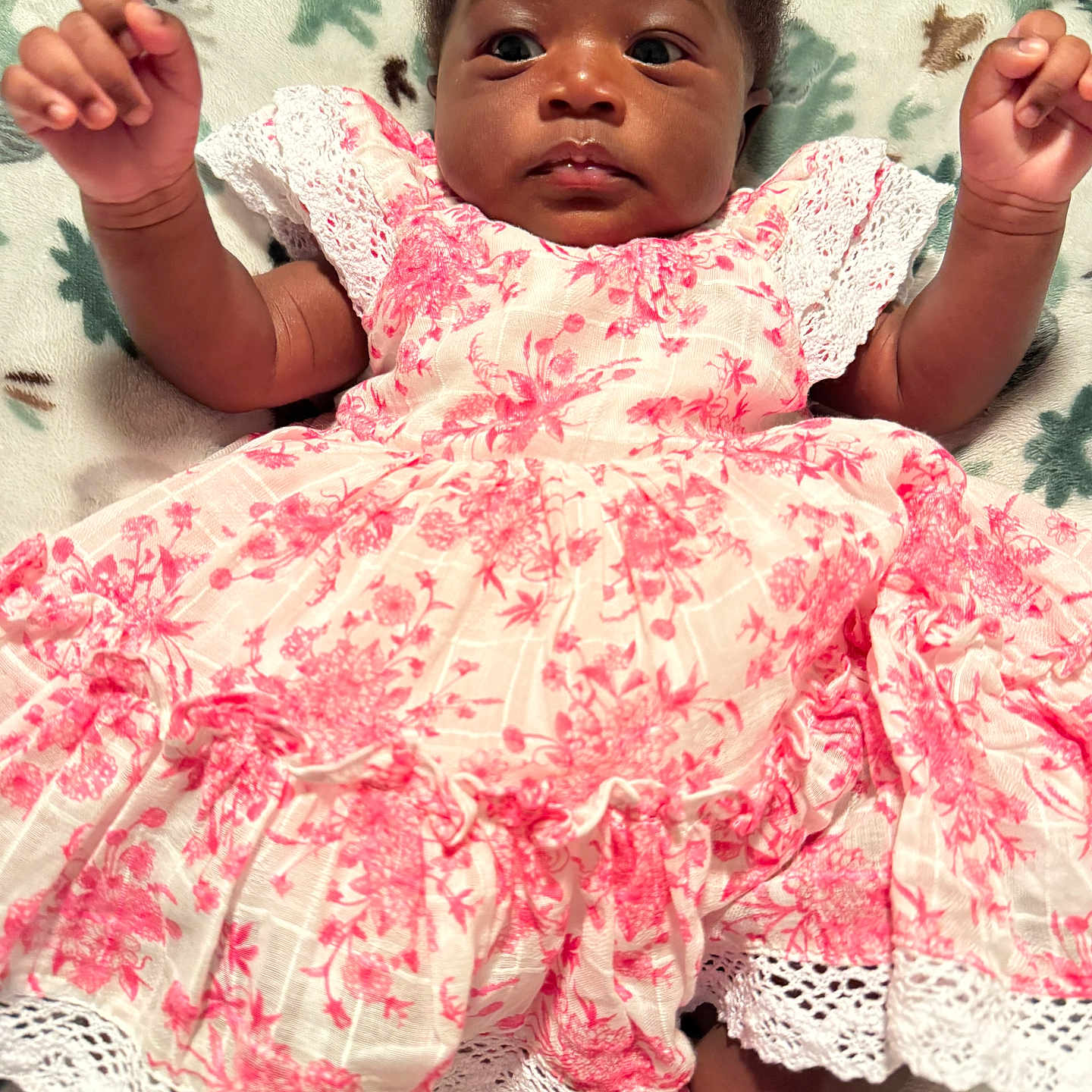 Liz is registered to the contest to win money with this photo: baby, child, infant, dress, pink, white, floral, blanket, arms, cute, portrait, lying_down, soft, patterned_blanket, indoors, person, young_child, happy, clothing, sock