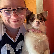 Chloe is registered to the contest to win money with this photo: person, dog, glasses, smile, indoor, pet, collar, fur, face, closeup, happy, casual_clothing, light, wall, hair, animal, cute, portrait, human, friendship