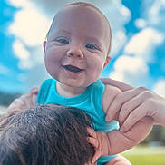 Cooper is registered to the contest to win money with this photo: baby, child, smiling, blue_sky, clouds, outdoor, person, shoulders, happy, face, hands, short_hair, holding, young_child, sunlight, nature, portrait, skin, joy, casual_clothing
