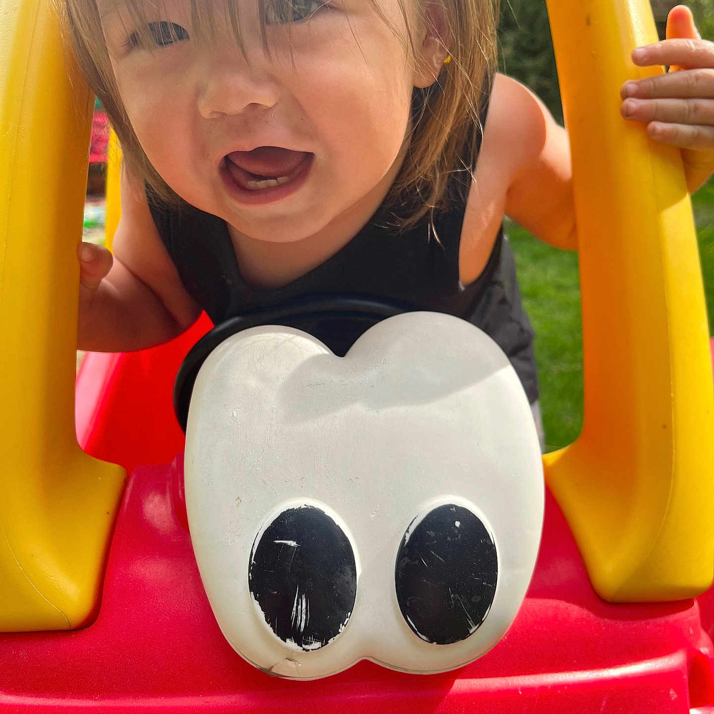 Paxton is registered to the contest to win money with this photo: bodypart, child, clothing, face, female, finger, girl, grass, hand, head, outdoorplayarea, outdoors, person, photography, plant, playarea, portrait, slide, t_shirt, toy