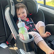 Victoria joined the competition — help win amazing prizes! toddler, car_seat, smiling, child, milk_bottle, car_interior, safety_harness, window, seatbelt, foot, pink_clothing, happy, baby, infant, seat, child_safety, daylight, portrait, vehicle, cute