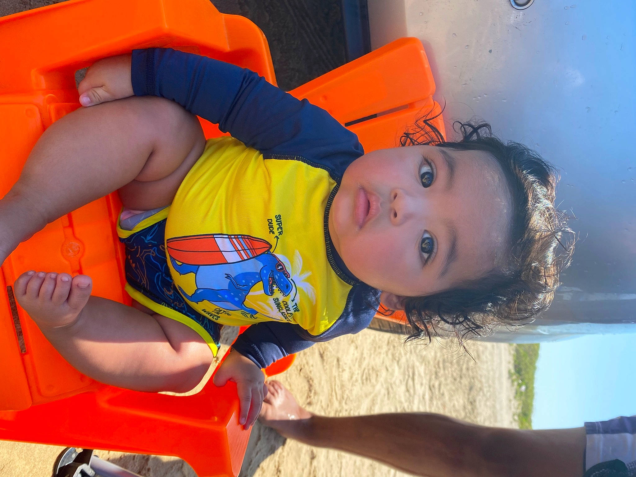 Alijah is registered to the contest to win money with this photo: arm, blue, child, elbow, electric_blue, facial_expression, fun, happy, human_leg, leisure, mouth, orange, person, play, recreation, smile, snapshot, summer, thigh, toddler