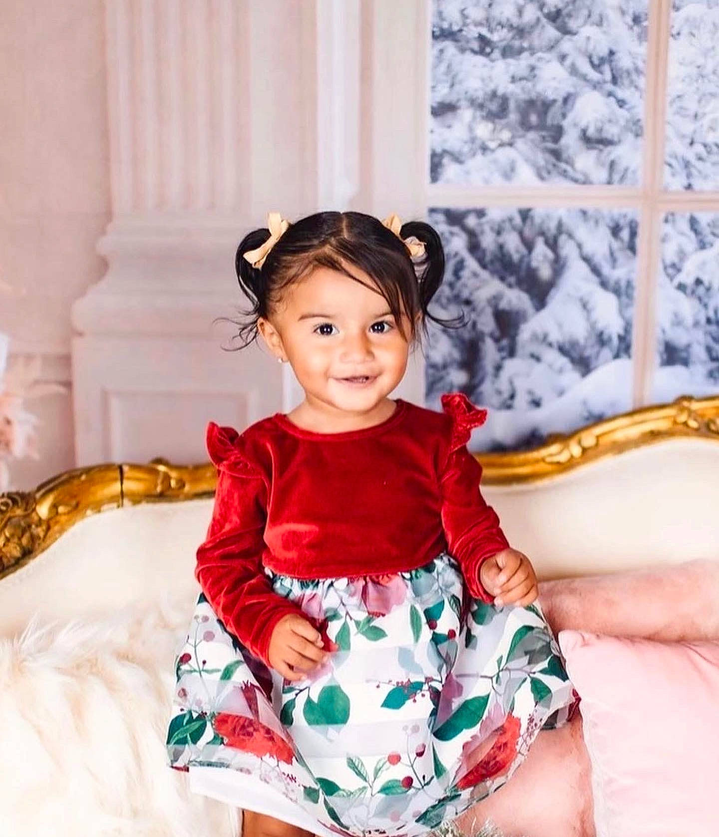 Lilliana is registered to the contest to win money with this photo: baby_toddler_clothing, child, comfort, day_dress, dress, event, fashion_design, formal_wear, fun, happy, joy, magenta, neck, one_piece_garment, pattern, person, purple, sitting, sleeve, smile
