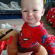 Paxton joined the competition — help win amazing prizes! baby, child, toddler, portrait, face, serious, expression, spiderman, superhero, red_clothing, costume, rocking_horse, toy, nursery, playroom, indoor, seated, wooden_floor, crib, colorful