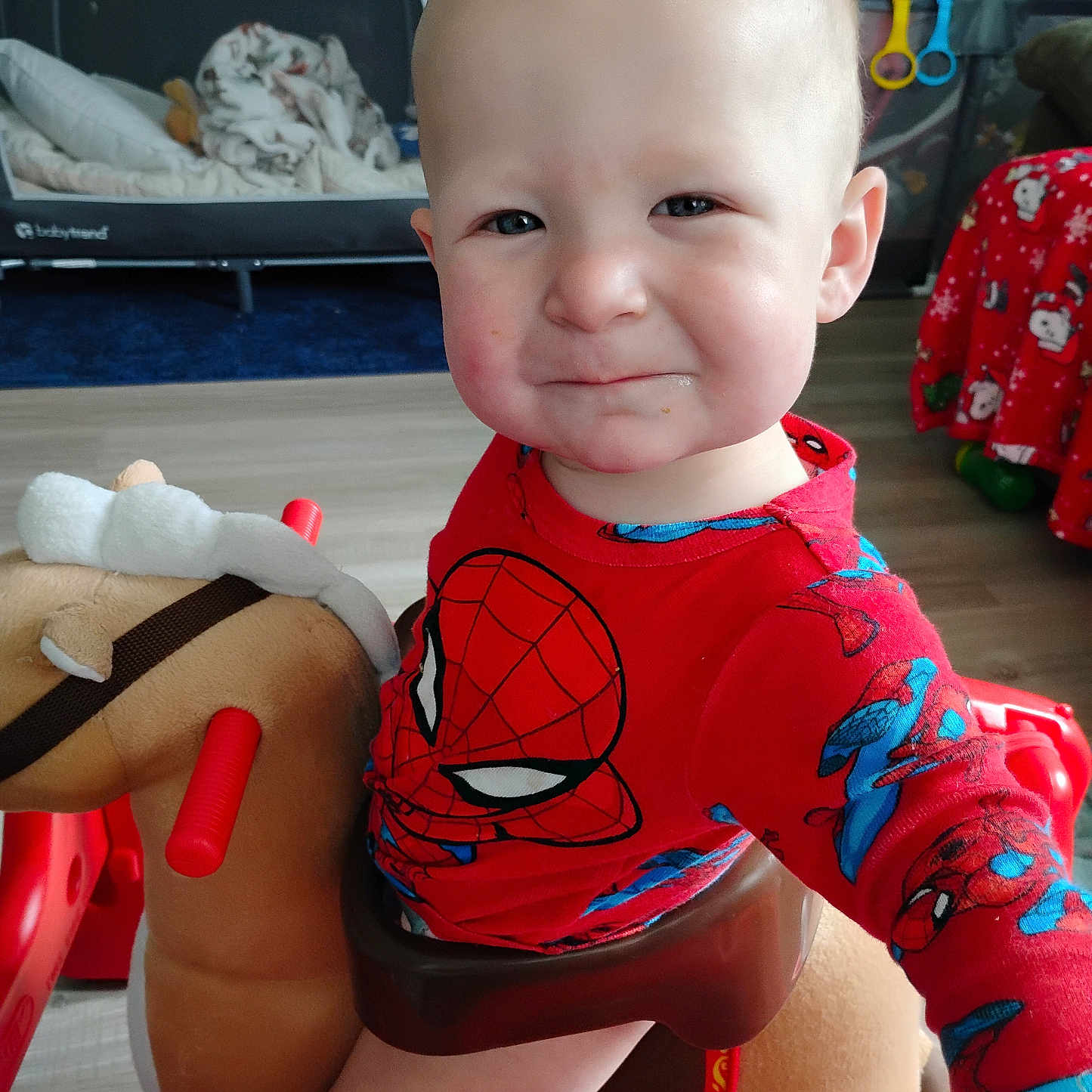 Paxton joined the competition — help win amazing prizes! baby, child, toddler, portrait, face, serious, expression, spiderman, superhero, red_clothing, costume, rocking_horse, toy, nursery, playroom, indoor, seated, wooden_floor, crib, colorful
