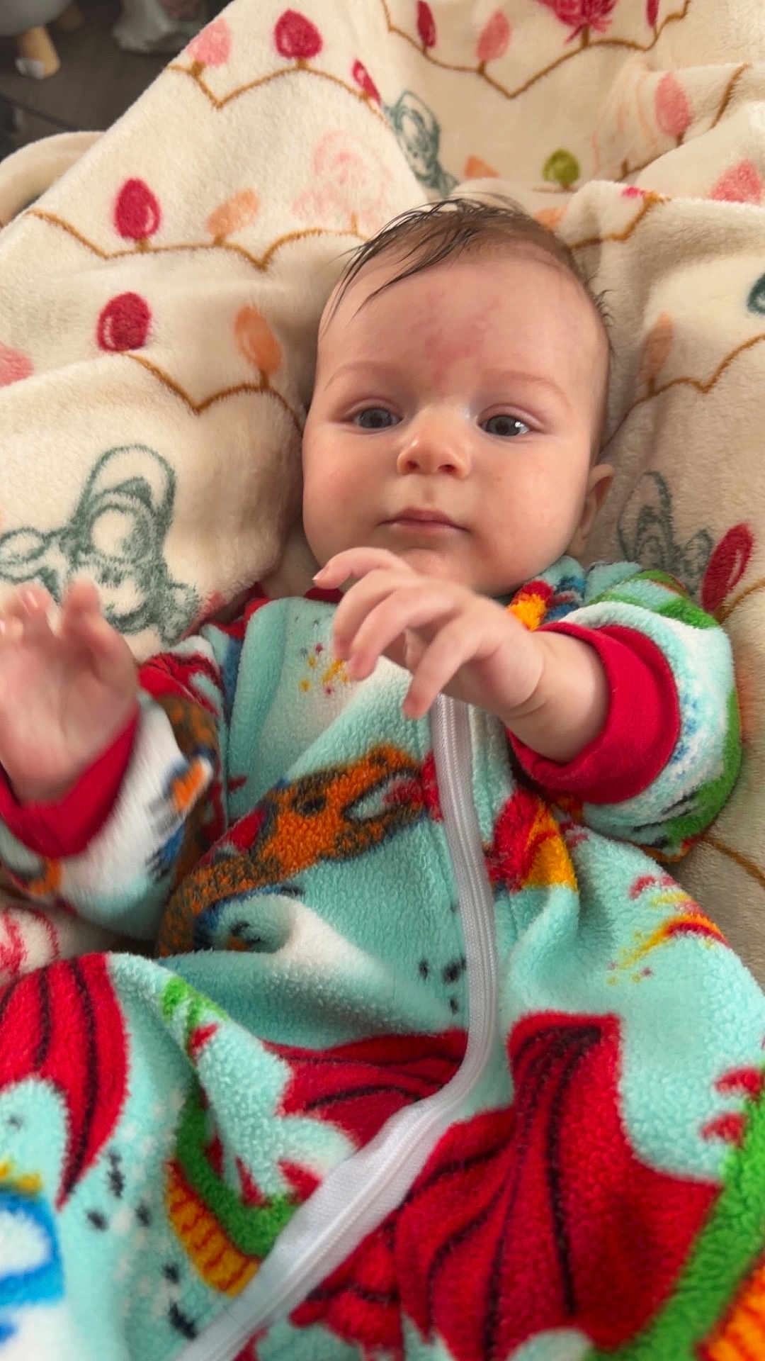 Barrett is registered to the contest to win money with this photo: baby, infant, fleece, blanket, colorful_clothing, hands, face, eyes, cozy, patterned_blanket, child, portrait, cute, warm, indoor, soft_texture, young_child, reaching, comfortable, sleepwear
