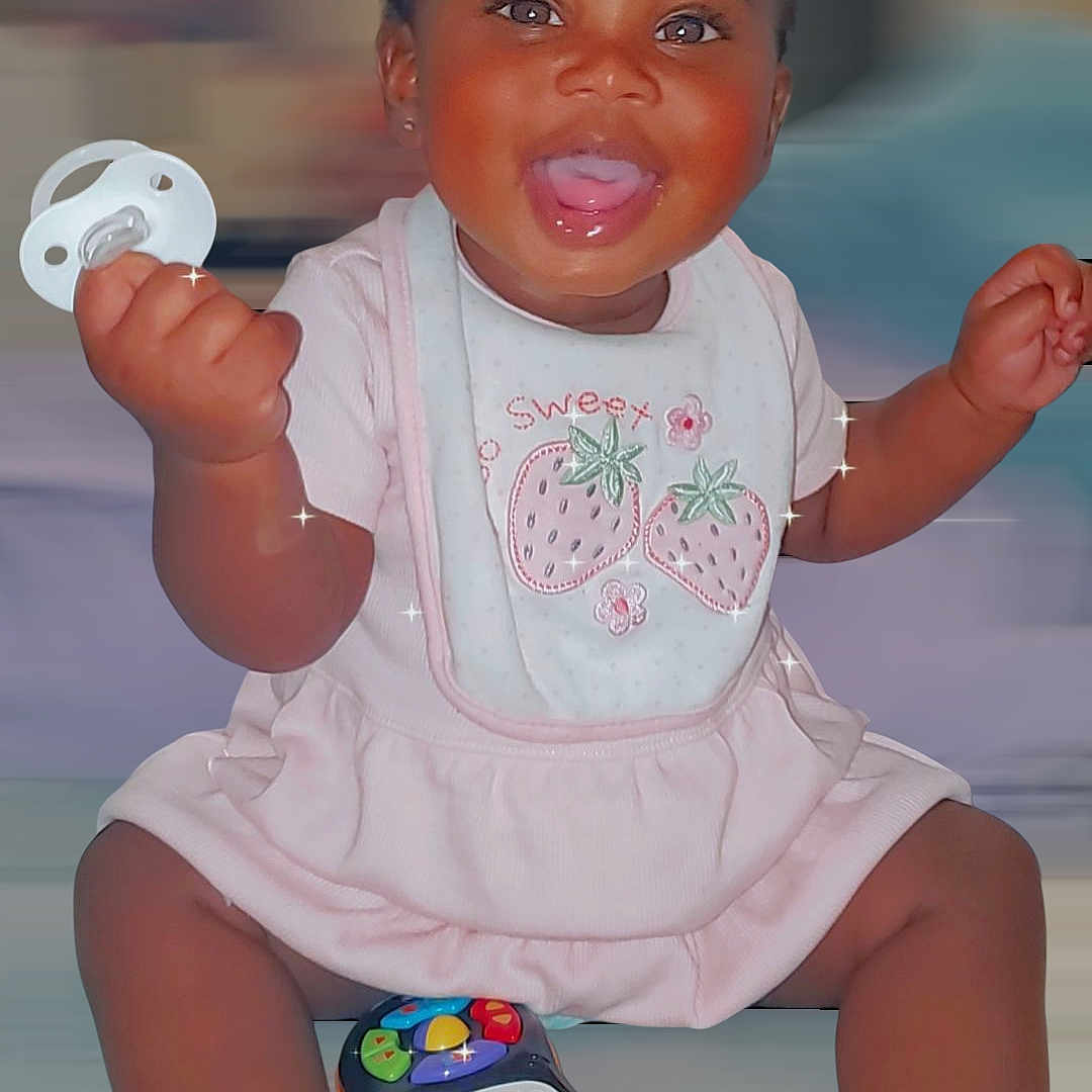Kardiaye joined the competition — help win amazing prizes! baby, bib, bows, cheerful, child, cute, dark_skin, hair_accessories, happy, indoors, infant, pacifier, pink_clothing, playful, portrait, short_hair, sitting, smiling, sparkles, toy_phone