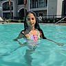 Nicole is registered to the contest to win money with this photo: apartment_building, balcony, child, colorful_clothing, girl, long_hair, outdoor, palm_trees, photography, pool, poolside, portrait, reflection, smiling, summer, sunny, swimming, swimsuit, vacation, water