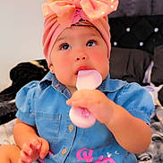 Mía Karla joined the competition — help win amazing prizes! adorable, baby, bedroom, blanket, bow, child, close_up, cozy, denim, frozen_treat, furniture, hand, headband, ice_pop, indoor, outfit, pink, portrait, sitting, smiling