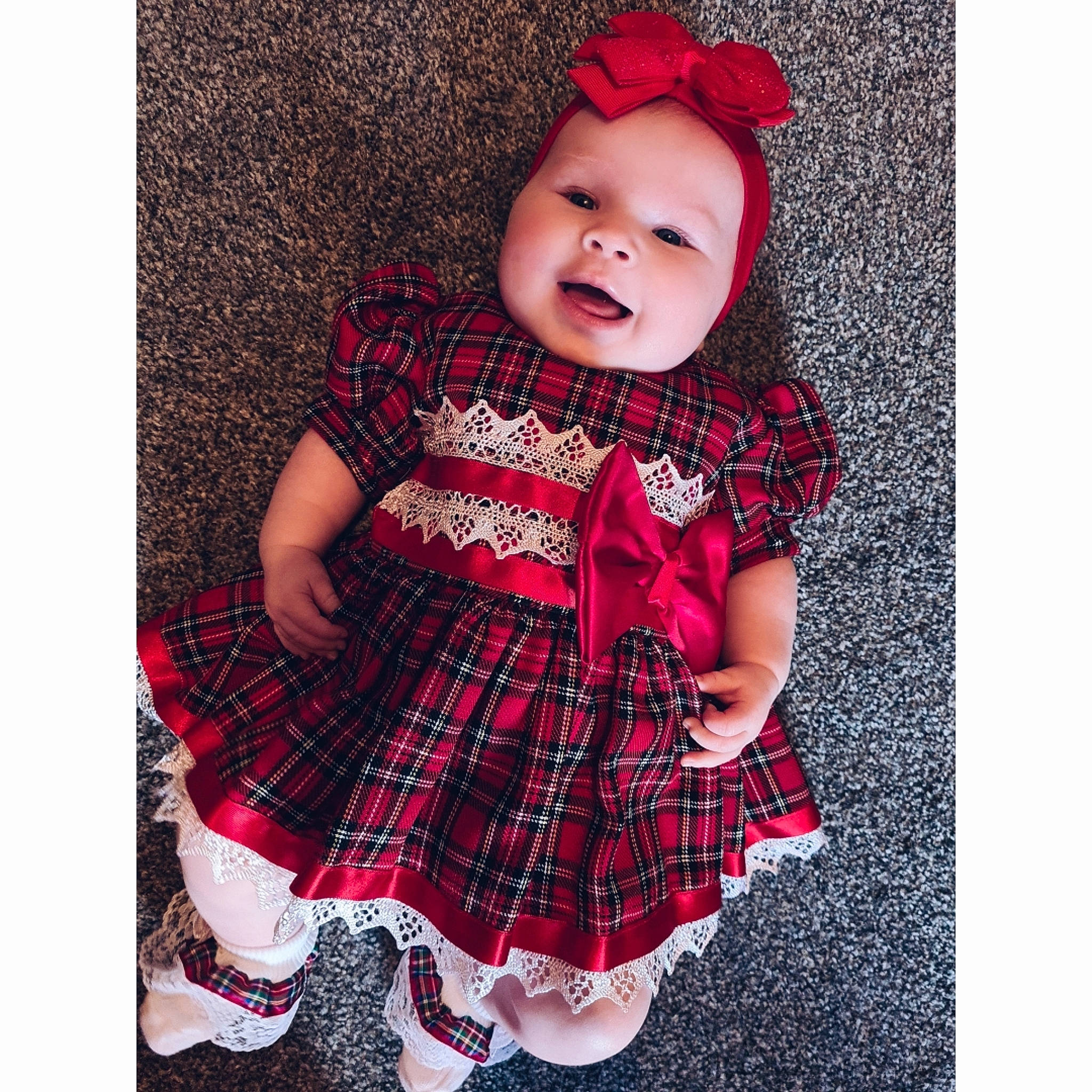 Georgie is registered to the contest to win money with this photo: baby, baby_toddler_clothing, cap, collar, costume_hat, day_dress, dress, dress_shirt, face, head, magenta, outerwear, pattern, person, plaid, sleeve, smile, t_shirt, tartan, textile