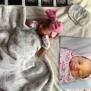 Amoura is registered to the contest to win money with this photo: baby, blanket, headband, pink_bow, ultrasound_images, swaddled, sleeping, mittens, photo_print, soft_texture, floral_pattern, newborn, infant, lying_down, cute, cozy, portrait, close_up, baby_clothing, nursery