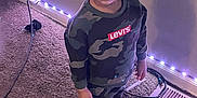 Khalil joined the competition — help win amazing prizes! child, indoor, carpet, wall, string_lights, camo_clothing, boots, standing, floor, cable, levis, curious_expression, young, person, hair_braids, casual, home, shadow, lighting, clothing