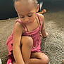 child, toddler, girl, blue_bow, pink_dress, pink_slippers, carpet, jewelry, bracelet, necklace, indoor, floor, toy, furniture, bed, cute, focused, sitting, hair, play