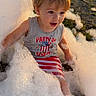 child, toddler, foam, bubbles, outdoor, sunlight, smiling, sitting, portrait, playful, blond_hair, gray_shirt, striped_clothing, usa_design, grass, park, soap, bath, happy, summer