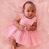 Zoe joined the competition — help win amazing prizes! baby, infant, child, portrait, pink_dress, tutu, sparkles, blanket, lying_down, face, hands, barefoot, bracelet, earrings, fashion, cute, indoor, pink_background, photography, smiling