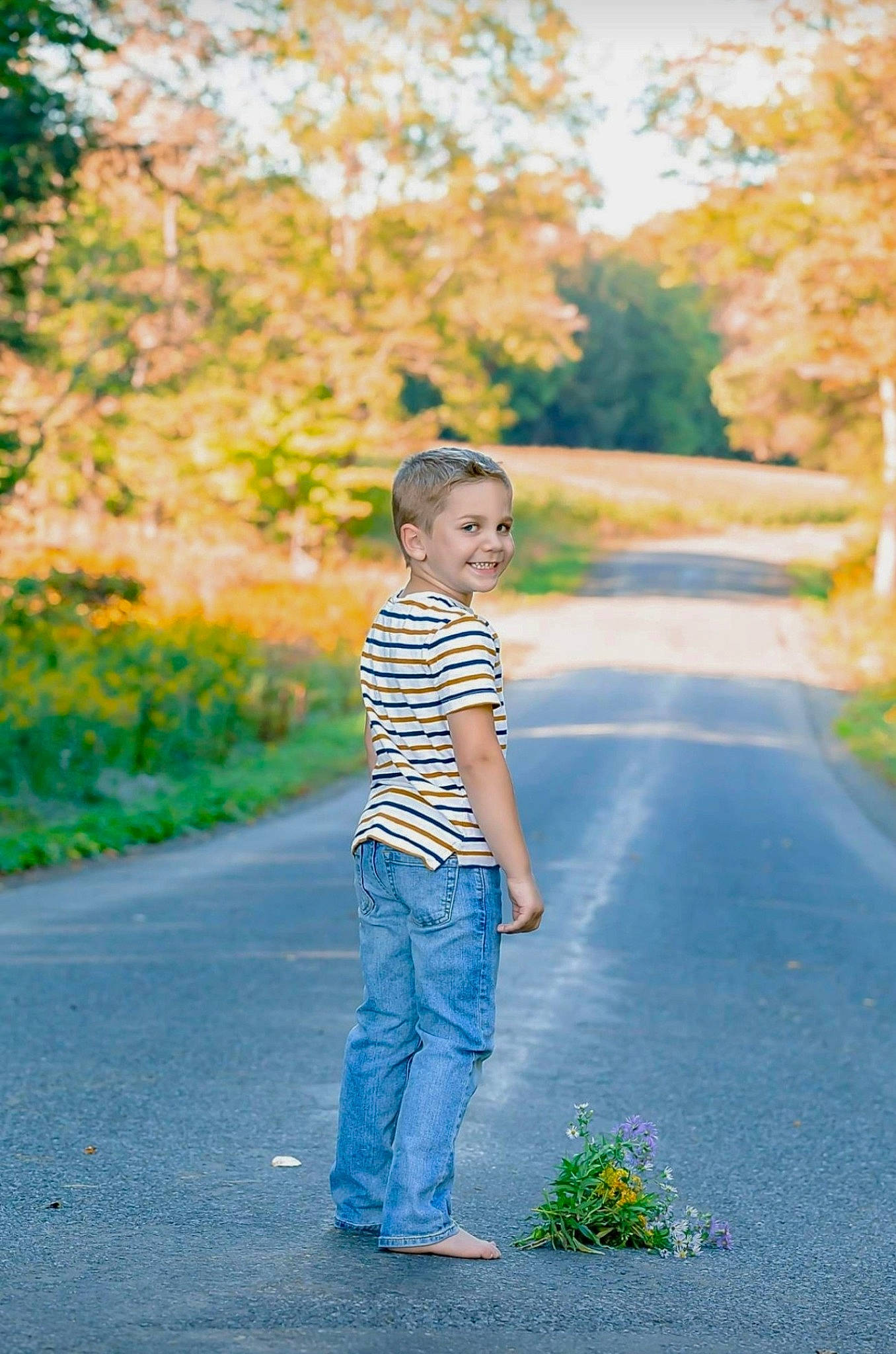 Kohen is registered to the contest to win money with this photo: asphalt, child, denim, fun, happy, jeans, joy, leaf, leisure, people_in_nature, person, photograph, photography, plant, road, standing, summer, sunlight, toddler, tree