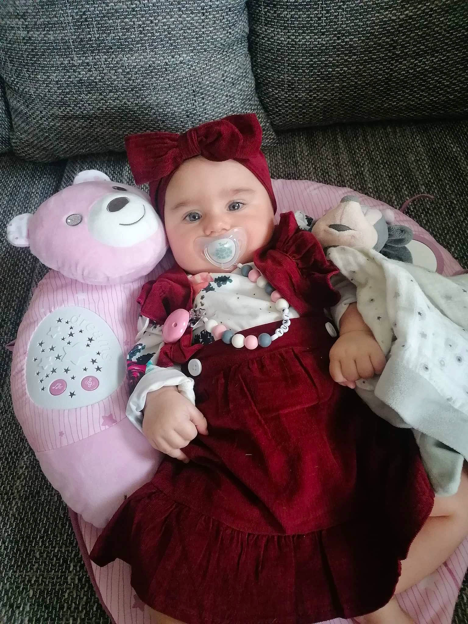 Yumi a rejoint le concours — aidez-le/la à gagner de superbes lots ! baby, baby_products, baby_toddler_clothing, cheek, child, comfort, doll, dress, head, headwear, pattern, person, pink, plush, purple, skin, sleeve, stuffed_toy, teddy_bear, textile