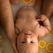 Gabriel a rejoint le concours — aidez-le/la à gagner de superbes lots ! baby, infant, bath, milk_bath, citrus_slices, lemons, oranges, hands, skin, water, relaxation, closeup, portrait, cute, peaceful, soft_light, fresh, healthy, natural, parent