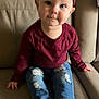 toddler, child, baby, bow, headband, burgundy, shirt, jeans, ripped_jeans, barefoot, couch, beige, furniture, indoor, portrait, smile, face, hands, feet, cute