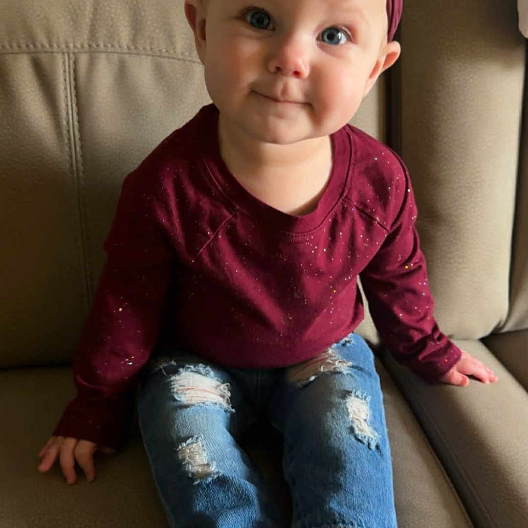 Roslynn joined the competition — help win amazing prizes! baby, barefoot, beige, bow, burgundy, child, couch, cute, face, feet, furniture, hands, headband, indoor, jeans, portrait, ripped_jeans, shirt, smile, toddler
