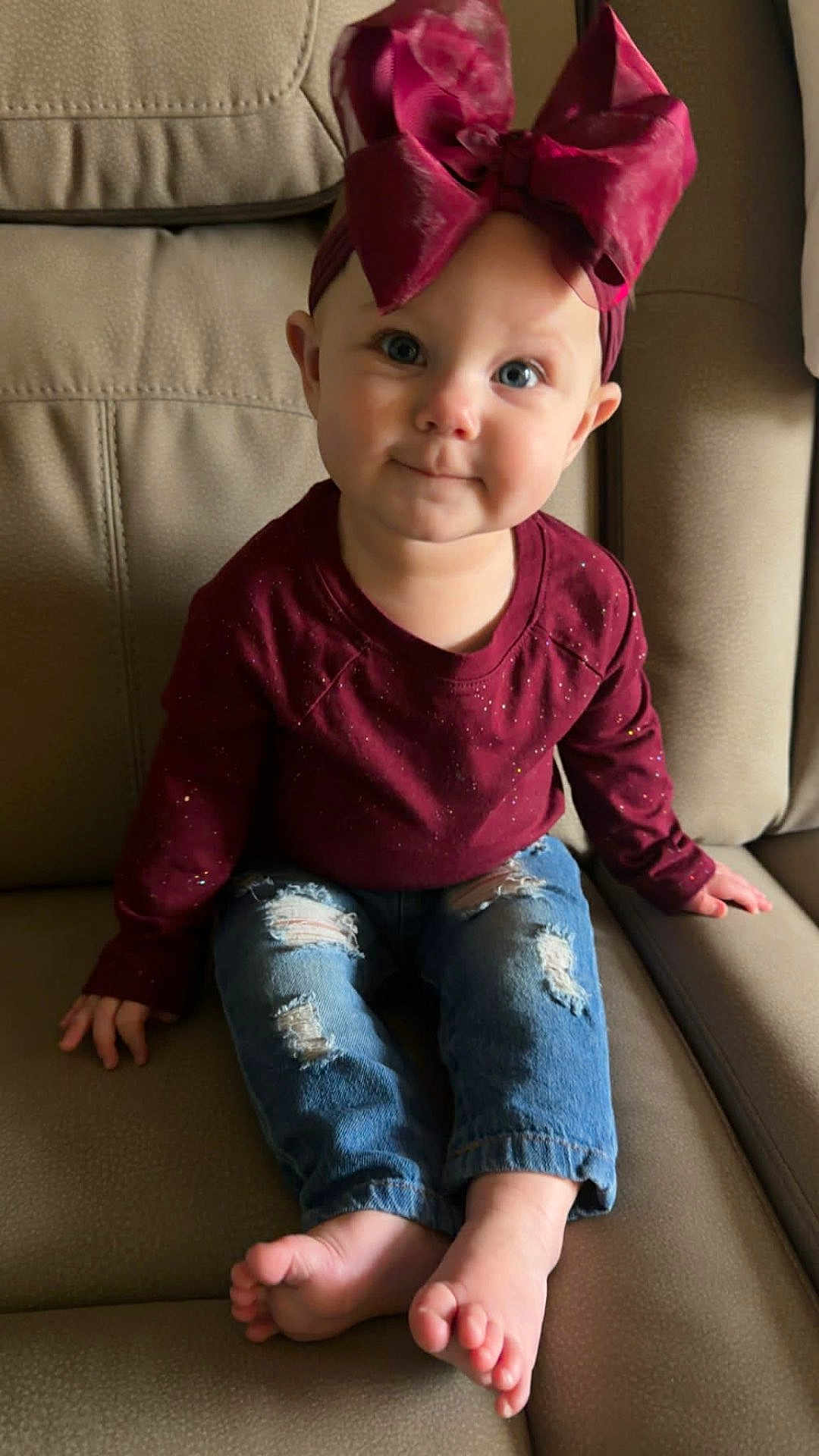 Roslynn joined the competition — help win amazing prizes! toddler, child, baby, bow, headband, burgundy, shirt, jeans, ripped_jeans, barefoot, couch, beige, furniture, indoor, portrait, smile, face, hands, feet, cute