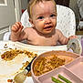 baby, child, high_chair, messy, spaghetti, food, plate, spoon, green_beans, meal_time, indoor, kitchen, headband, face, blue_eyes, expression, cute, feeding, toddler, person
