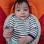 baby, blue_pants, child, clothing, cushion, cute, expression, face, hands, indoors, infant, looking, orange, person, portrait, red, seat, sitting, striped_shirt, young