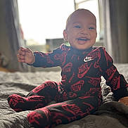 Kayson-Jay joined the competition — help win amazing prizes! baby, smiling, child, nike, clothing, indoor, bed, blanket, happy, portrait, infant, cute, sitting, cozy, apparel, person, soft_light, window, home, young