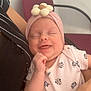 Luna a rejoint le concours — aidez-le/la à gagner de superbes lots ! baby, smile, headband, flower, onesie, cartoon, person, arm, chair, indoor, clothing, infant, cute, happy, resting, holding, pink, white, pattern, striped
